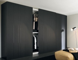 Černá dřevěná šatní skřín s posuvnými dveřmi v ložnici